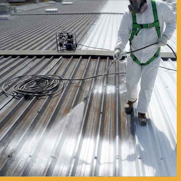Commercial roofing in Sarnia, with worker spraying the roof.









